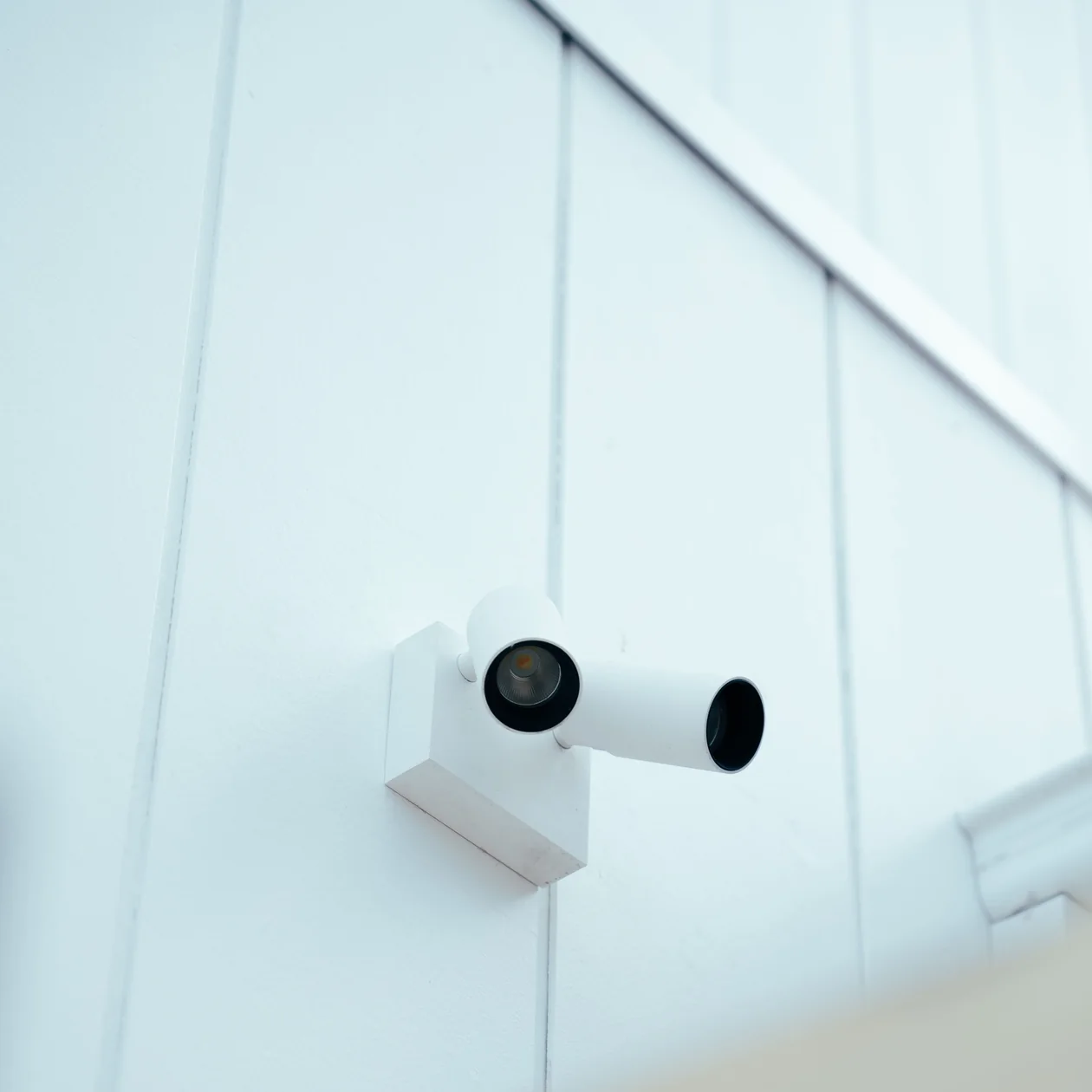 White twin-head spotlight mounted on white exterior cladding
