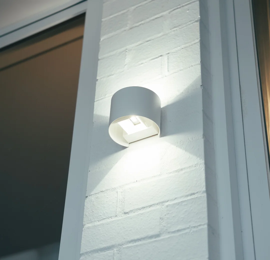 Up and down wall light on a painted brick wall