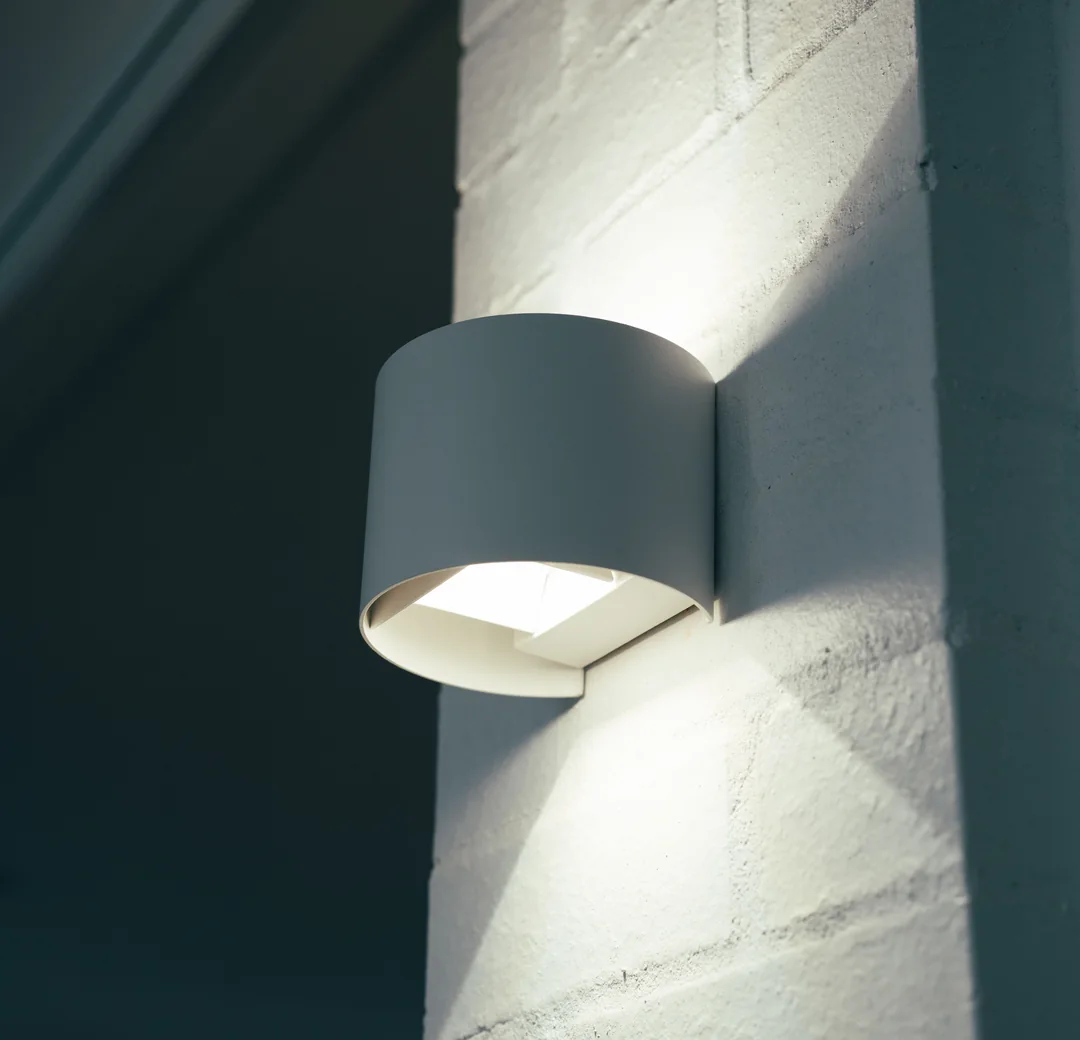 Up and down wall light mounted on a painted brick exterior