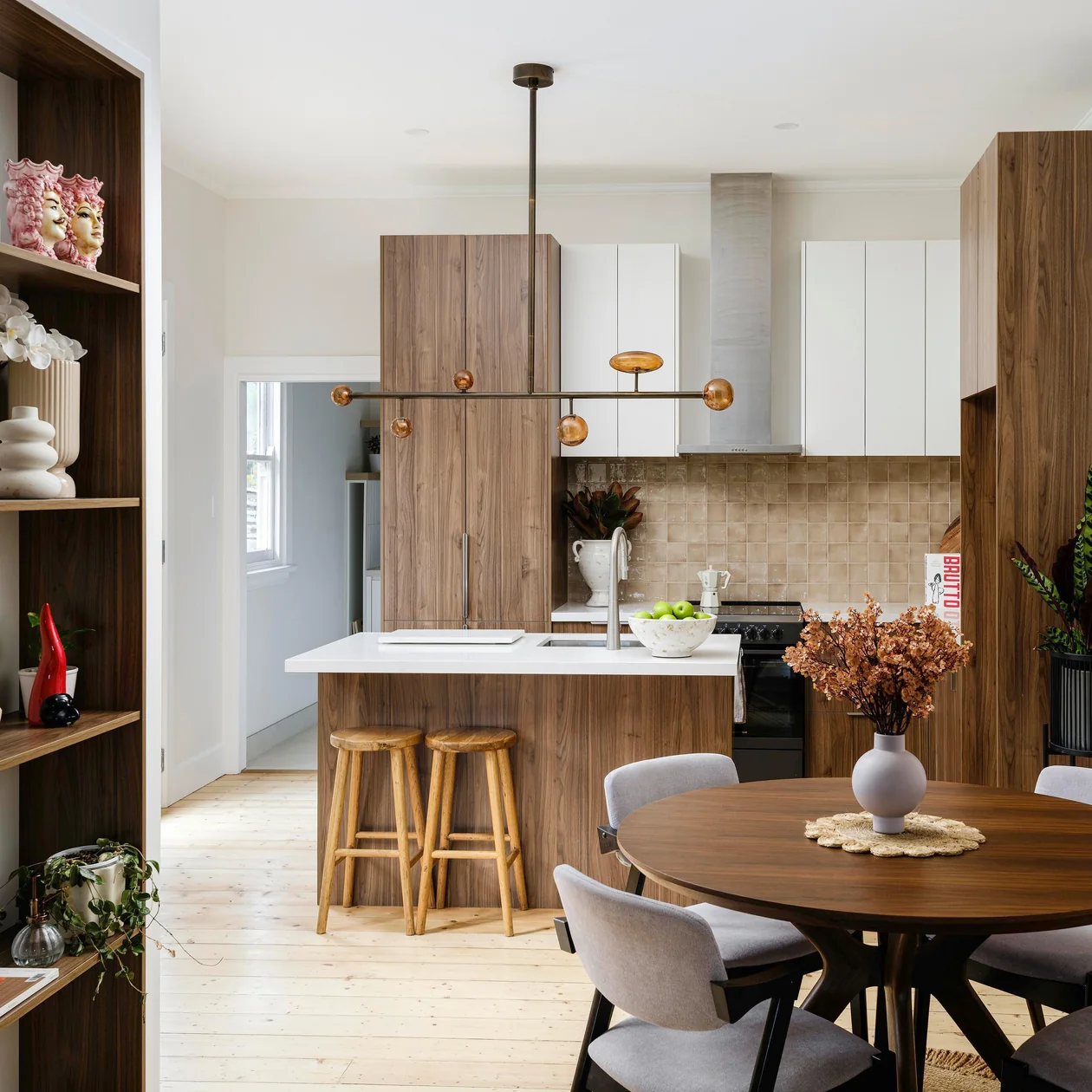 Kitchen and dining area with a linear pendant light above a timber island