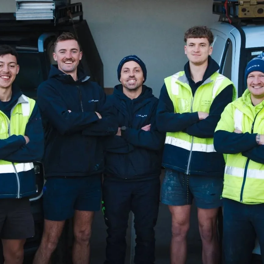 The LPL Electrics Group team standing in front of their work vehicles