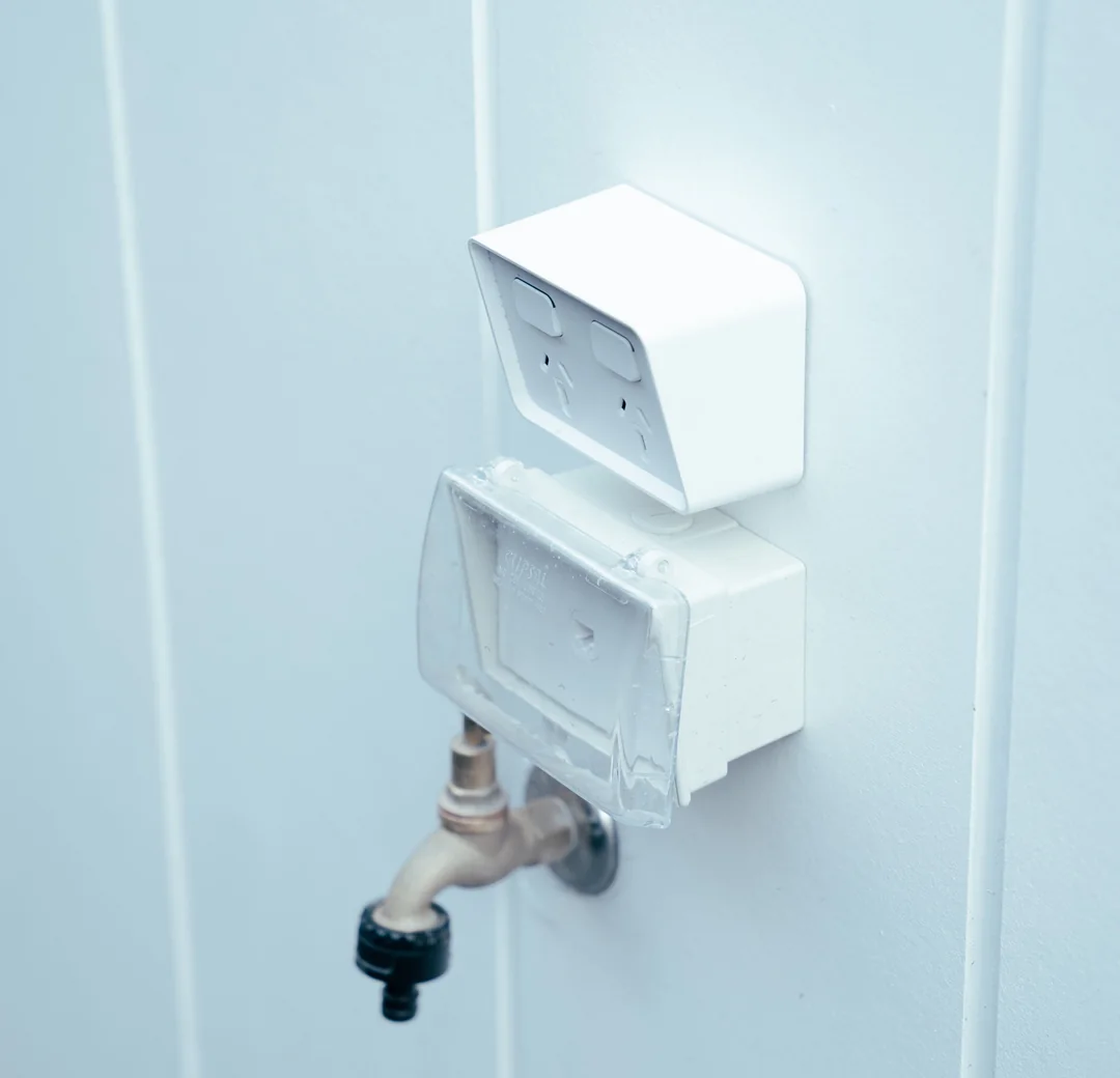 White weatherproof double power point mounted on an exterior wall