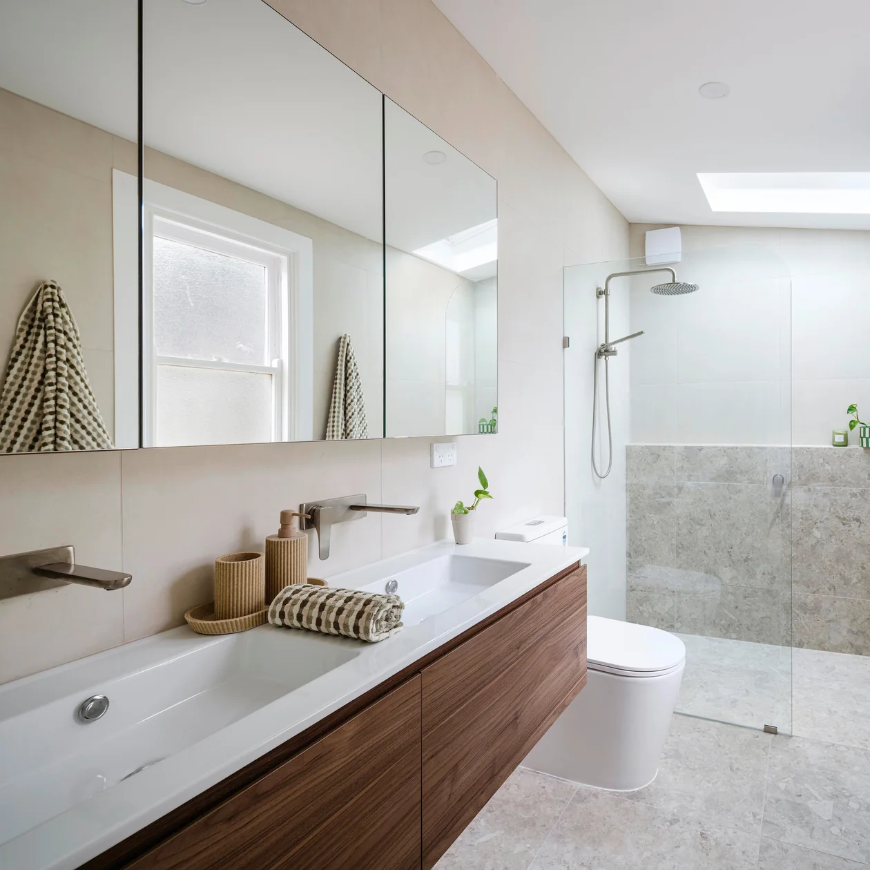 Renovated bathroom with a timber vanity and a skylight above the shower