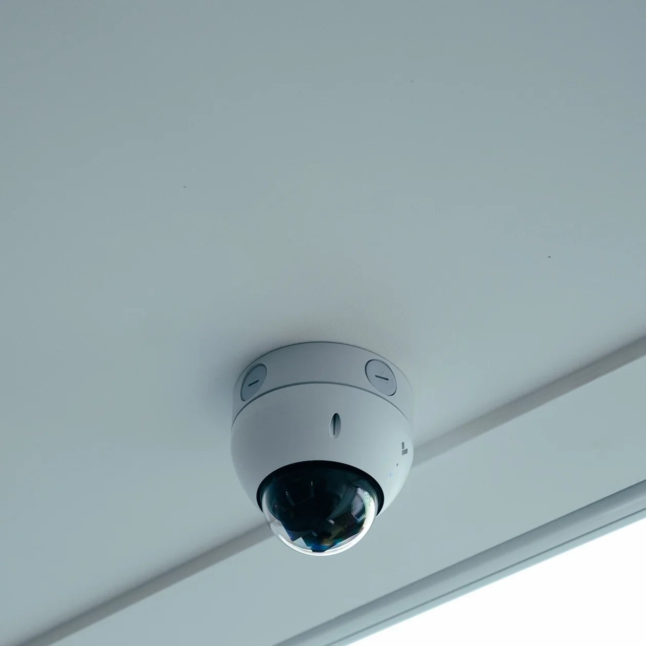 White dome security camera mounted on a ceiling